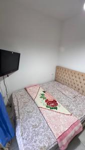 a bed with a quilt on it in a room at la petite sirène in Mahdia