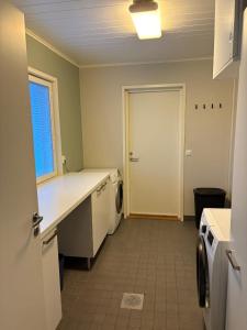 una cocina con lavadora y secadora y una puerta en House Venni, en Rovaniemi