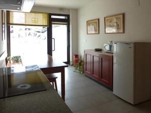 a kitchen with a refrigerator and a table in it at Hostal Caracas in Lalín