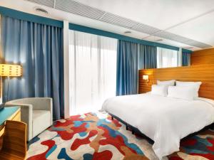a hotel room with a bed and a chair at Mercure Tallinn in Tallinn +140 photos