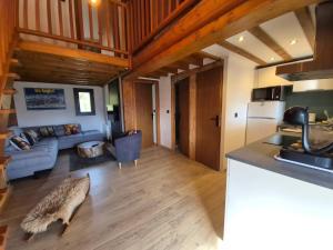 eine Küche und ein Wohnzimmer mit einer Couch und einem Tisch in der Unterkunft Chalet 8 couchages à 100m du bas des pistes et commerces in Les Angles