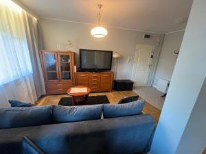 a living room with a couch and a tv at Apartament Park in Słupsk
