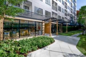 a building with glass windows and plants in a courtyard at Chic Vay Central Pattaya Condo in Pattaya North