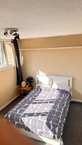 Un dormitorio con una cama con un edredón azul y blanco. en Enfield court, en Enfield