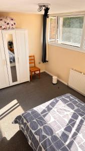 Un dormitorio con una cama y un armario y una ventana. en Enfield court, en Enfield