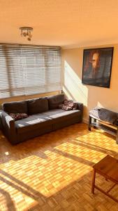 Una sala de estar con un sofá y suelo de madera. en Enfield court, en Enfield
