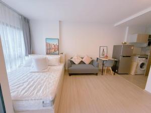 a bedroom with a bed and a couch and a table at Chic Vay Central Pattaya Condo in Pattaya North