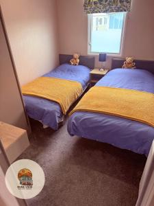 a room with two beds with teddy bears on them at Dune View Caravan in Ynys-lâs Station