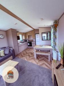 a living room with a couch and a table at Dune View Caravan in Ynys-lâs Station