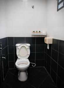 クアンタンにあるJawa Stayの黒いタイル張りの客室で、バスルーム(トイレ付)が備わります。