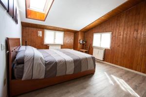 Un dormitorio con una cama en una habitación con paredes de madera. en Casa Liscidini, en Aprica