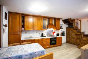 cocina con armarios de madera, fregadero y fogones en Casa Liscidini, en Aprica