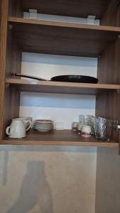 a wooden shelf with plates and dishes on it at Aley Pilot Residence in Al Qammāţīyah
