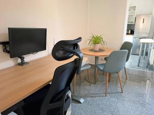 Habitación con escritorio, TV y mesa. en Apartment in Remagen am Rhein, en Remagen