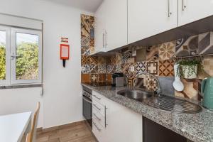 a kitchen with a sink and a counter top at Casa das Laranjeiras in Alfarim