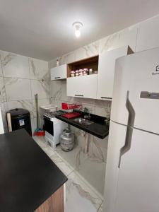 une cuisine avec un réfrigérateur blanc et un comptoir dans l'établissement Apartamento completo -João Pessoa 2 quartos -praia do sol, à João Pessoa 1 autre photo