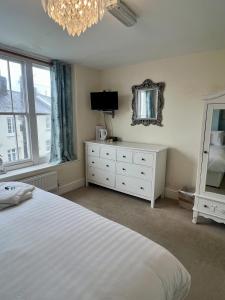 a bedroom with a bed and a mirror and a dresser at The Wayfarer Inn in Instow
