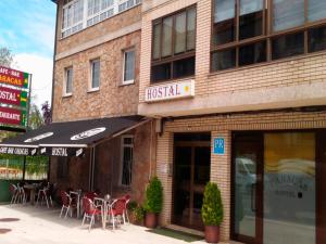 a restaurant with tables and chairs in front of a building at Hostal Caracas in Lal&iacute;n