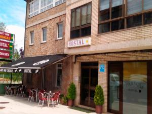 a restaurant with tables and chairs in front of a building at Hostal Caracas in Lalín