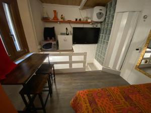 a room with a desk and a television and a bed at Mini House centro storico Duomo di Pavia in Pavia