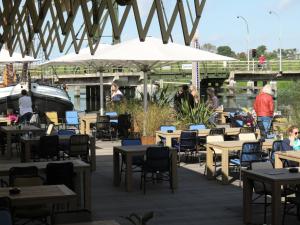 een patio met tafels en stoelen en een brug bij Tiny Boat House #4 in Garnwerd