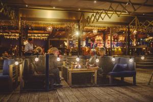 een groep mensen die aan een tafel in een restaurant zitten bij Tiny Boat House #4 in Garnwerd