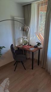 a desk with a chair and a lamp in a room at Viktor Apartment in Titisee-Neustadt