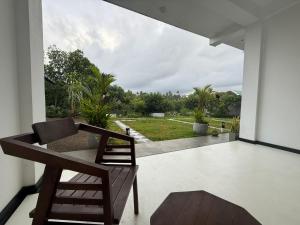 a living room with a chair and a view of a yard at Natural Lake Down South in Habaraduwa