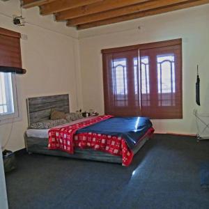 a bedroom with a bed with a red blanket on it at Cottage De Hunza- A Soul Retreat Sanctuary in Hunza