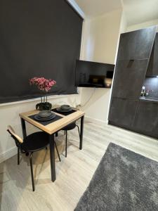 a room with a table with a vase of flowers on it at Sunny Stay Studio in Grove Park