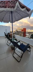 a chair under an umbrella on a roof at privat Room in Shard Appartement step by mosquée Hassan 2 in Casablanca