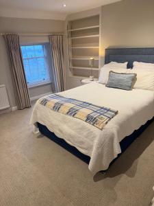 a bedroom with a large bed and a window at Vine House in Tetbury