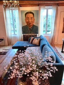 a living room with a blue couch and a painting at L'heure bleue in Saintes