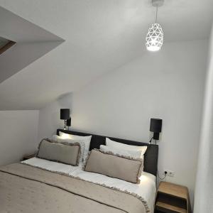 a bedroom with a bed with two pillows on it at Central Apartment in Zetea