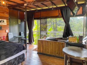 a bedroom with a bed and a kitchen and a balcony at San Sebastián barbosa in Barbosa