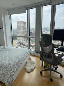 ロンドンにある62 Sqm High Rise Apartment Canary Wharfのベッドルーム1室(ベッド1台、椅子、窓付)