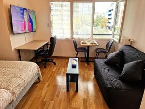 a living room with a couch and a table at Studio Europarc Créteil - 2mn Métro 8 - Paris in Créteil