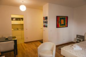 ベオグラードにあるMaja Apartmentのベッド、デスク、キッチンが備わる客室です。