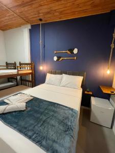a bedroom with a large bed and a blue wall at Ilha Grande Trip in Abraão