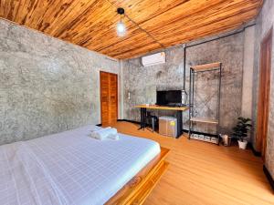 a bedroom with a bed and a desk in it at ดิน ดาว หนาว หมอก in Khao Kho
