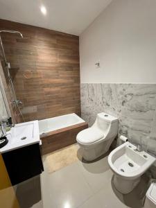 a bathroom with a toilet and a sink and a tub at Atardecer Aparts in Escalante