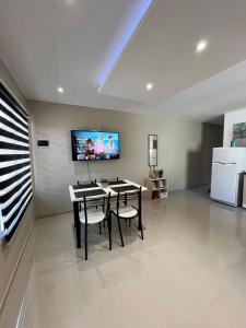 a dining room with a table and a tv on the wall at Atardecer Aparts in Escalante +4 photos