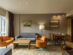 a living room with a couch and a table at Movenpick Resort and Spa Fruske Terme in Vrdnik +249 photos