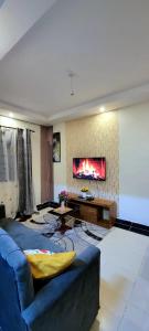 a living room with a blue couch and a fireplace at GoldenSpark Homes in Thika