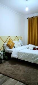 a bedroom with two beds with white sheets and pillows at GoldenSpark Homes in Thika
