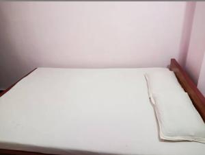 een bed in een kamer met een wit matras bij Sri Hotel Ganga in Patna