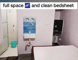 een badkamer met een wastafel en een schilderij aan de muur bij Sri Hotel Ganga in Patna