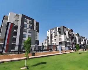 a row of apartment buildings with a tree in a field at 2 Bedroom Modern Flat at Zayed in 6th Of October