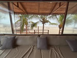 a couch in a room with a view of a beach at Casa de Playa Alarcon - Huacura in Bocapán