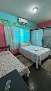 una stanza con due letti in una stanza di Aráras Suites a Palmas